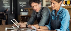 Hospitality business owners reviewing receipts and costs to manage cash flow, pricing and business performance
