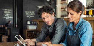 Hospitality business owners reviewing receipts and costs to manage cash flow, pricing and business performance