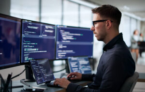 Technology professional working across multiple screens, reflecting investment in AI, digital tools and productivity improvements highlighted in the Thrive Index.
