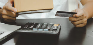 Business owner holding a supplier gift card received through a trade loyalty programme